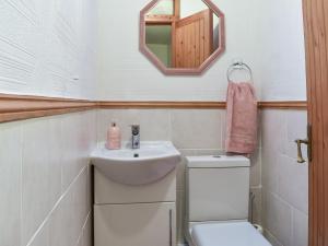 a bathroom with a sink and a toilet and a mirror at West Kellet in Silecroft