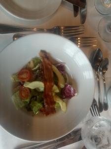 a bowl of food with bacon and salad on a table at Tanna Lava View Bungalows in Lénakel