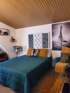 1 dormitorio con 1 cama azul y 1 silla en Catespero Sossego, en Reguengos de Monsaraz