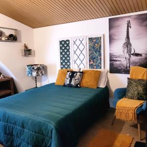 1 dormitorio con 1 cama azul y 1 silla en Catespero Sossego, en Reguengos de Monsaraz