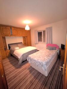 a bedroom with two beds and a window at Cosy 3 Bed Retreat in Omagh in Omagh