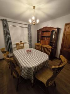 a dining room with a table and chairs with a table and a chandelier at Cosy 3 Bed Retreat in Omagh in Omagh