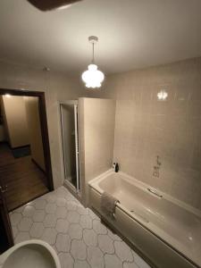 a bathroom with a tub and a toilet and a sink at Cosy 3 Bed Retreat in Omagh in Omagh