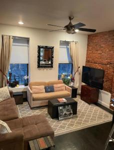 a living room with a couch and a flat screen tv at Fab 3 Bedroom 1Bath Apartment in NYC! in New York