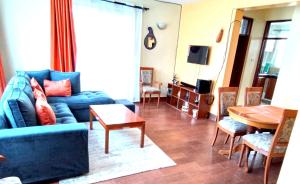 基蘇木的住宿－AVISHAI HOMES，客厅配有蓝色的沙发和桌子
