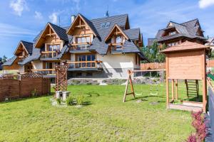 a large house with a playground in the yard at Domy Mountain Premium in Kościelisko