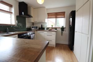 a kitchen with white cabinets and a counter top at Perfect 2 Bedroom Flat Heathrow, Free Parking in Shepperton