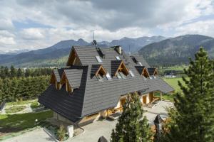 dom z czarnym dachem z górami w tle w obiekcie Domy Mountain Premium w mieście Kościelisko
