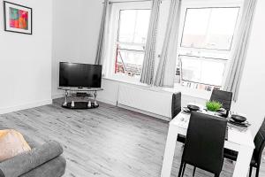 uma sala de estar com uma televisão de ecrã plano e um sofá em Inviting 3-Bed Apartment in Bromley em Bromley