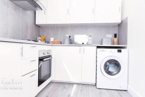 a white kitchen with a washing machine in it at Inviting 3-Bed Apartment in Bromley in Bromley