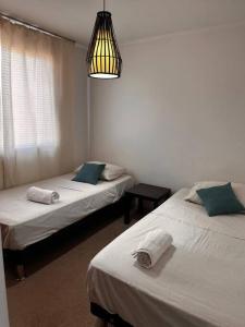 um quarto com duas camas e um candeeiro em Beautiful Confortable House em Estación Colina