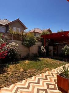 une cour avec une clôture et une terrasse dans l'établissement Beautiful Confortable House, à Estación Colina