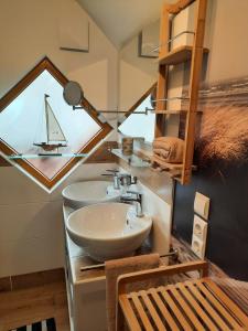 a bathroom with a sink and a sailboat window at Ferienwohnung Kalle in Osterbruch