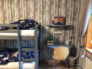 a bedroom with two bunk beds and a chair at Ferienwohnung Kalle in Osterbruch