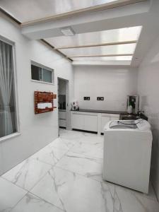 Cette grande chambre dispose d'un sol en marbre blanc et d'un appareil. dans l'établissement Apartamento inteiro com área e garagem privativa, à Belo Horizonte