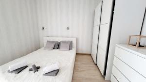 ein weißes Schlafzimmer mit einem Bett mit zwei Kissen in der Unterkunft Na Żeglarskim Szlaku WJM in Giżycko
