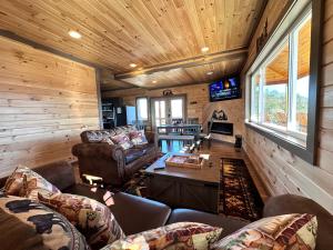 a living room with couches and a tv in a cabin at 7 BEARS Stunning views in Sevierville