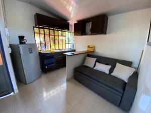 a living room with a couch and a kitchen at VILLA SOFI in Quimbaya