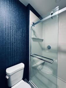 uma casa de banho com um WC e uma cabina de duche em vidro. em Hotel Scottsdale em Scottsdale