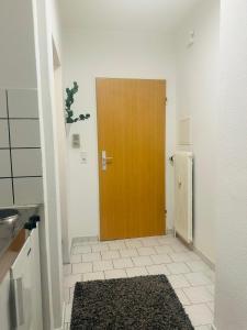 una porta marrone in una stanza bianca con un tappeto di SaNa Immobilien a Spenge