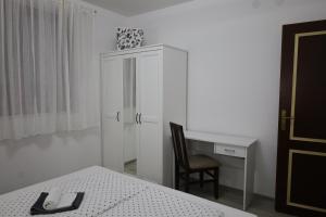 1 dormitorio con escritorio, silla y armario blanco en Hacijenda en Vukovar