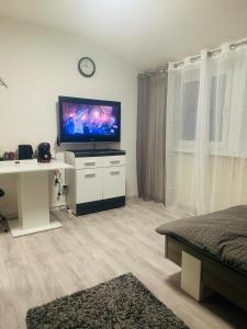een woonkamer met een flatscreen-tv en een bureau bij SaNa Immobilien in Spenge