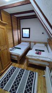 Habitación con 2 camas y alfombra. en Zlatni Hrast, en Pale