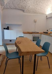 een keuken met een houten tafel en blauwe stoelen bij Casa D'Alma in Turijn