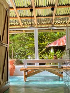 un banc en bois assis sous une pergola en bois dans l'établissement Rancho Romana Retreat N-05, à El Limón