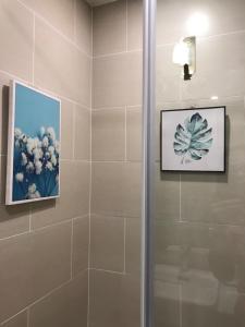 uma casa de banho com um chuveiro e uma imagem na parede em Minh An Homestay em HÆ°ng YÃªn