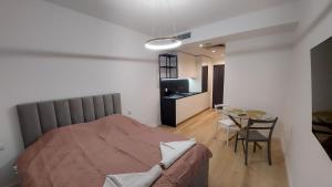 a bedroom with a bed and a table and a kitchen at Poznań Plac Wolności 6 Bond in Poznań