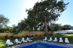 a group of lounge chairs and a swimming pool at Hotel Pedasí Nature Paradise in Pedasí Town