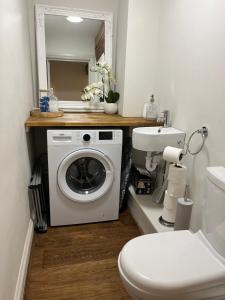 a bathroom with a washing machine and a toilet at The Old Surgery in Salisbury