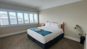 a bedroom with a large bed and a large window at Elegant Home with Seaview in Auckland