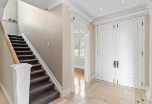 a staircase in a home with white walls at Elegant Home with Seaview in Auckland