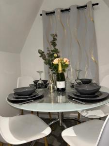 a dining room table with plates and a bottle of wine at 2 bed Apartment in Chapeltown in Roundhay
