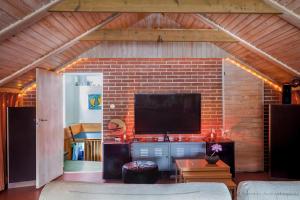 a living room with a tv and a brick wall at Villa Berkle in Stockholm