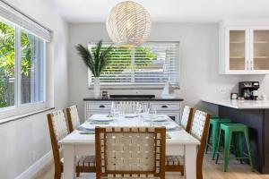 une salle à manger avec une table et des chaises blanches dans l'établissement Cozy home at Lighthouse Point with Pool 1, à Lighthouse Point