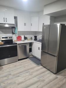 a kitchen with stainless steel appliances and white cabinets at Covenant Properties in Edmonton