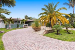 a brick driveway in front of a house with palm trees at Newly renovated 3 bedrooms near the beach and res1 in Pompano Beach
