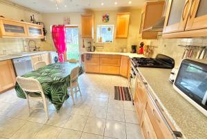 a kitchen with a table with a green table cloth on it at Grande Maison familiale bien équipée avec Billard in Chaunay