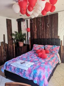 a bedroom with a bed with red and white balloons at The Frailejon House in Bogotá