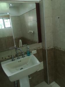 y baño con lavabo y espejo. en The Frailejon House, en Bogotá