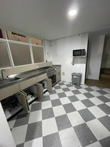 an empty kitchen with a checkered floor at Hostel Movistar Arena in Bogotá