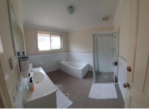 y baño con ducha, lavabo y bañera. en A little bedroom for you (3), en Warwick Farm