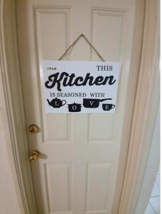 Una puerta con una señal que lee esta cocina está condimentada con gatos en A little bedroom for you (3), en Warwick Farm