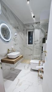 een witte badkamer met een wastafel en een spiegel bij Bllok Scandi Urban Apartments 1 in Tirana