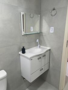 Un baño con un lavabo blanco y un espejo. en Casa completa - Governador Celso Ramos à 15min da praia de palmas, en Governador Celso Ramos 23 fotos más