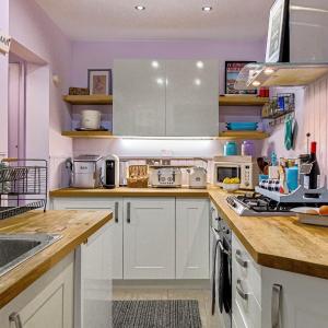 a kitchen with white cabinets and a counter top at Lilac Cottage Morpeth Northumberland in Morpeth