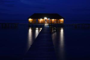 a house on a dock at night with lights at Ora Sunrise View in Kaloa